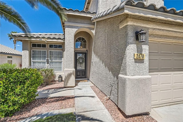 2470 Lower Meadows Ave, Henderson, NV 89052 - property entrance featuring a tiled roof, stucco siding, and an attached garage