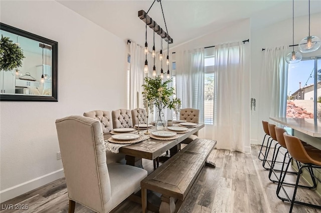 2470 Lower Meadows Ave, Henderson, NV 89052 - dining area featuring vaulted ceiling, plenty of natural light, wood finished floors, and baseboards