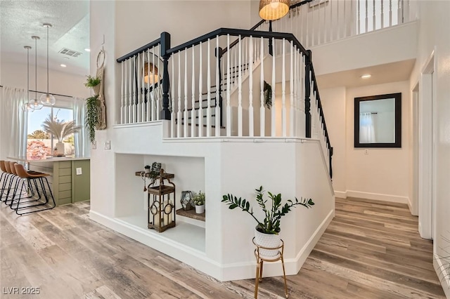 2470 Lower Meadows Ave, Henderson, NV 89052 - stairs with a high ceiling, wood finished floors, baseboards, and recessed lighting