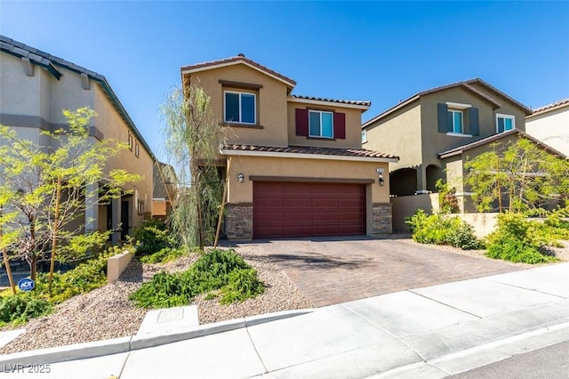 view of front of property with a tile roof, an attached garage, stucco siding, decorative driveway, and stone siding