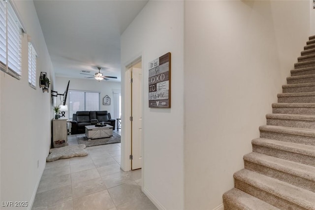 staircase featuring ceiling fan, tile patterned flooring, and baseboards