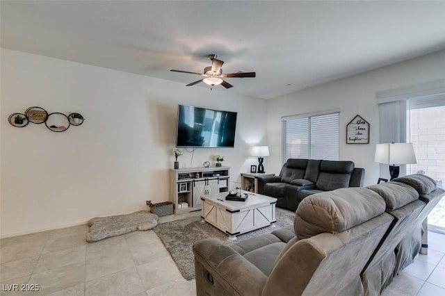 living room featuring plenty of natural light, ceiling fan, light tile patterned floors, and baseboards