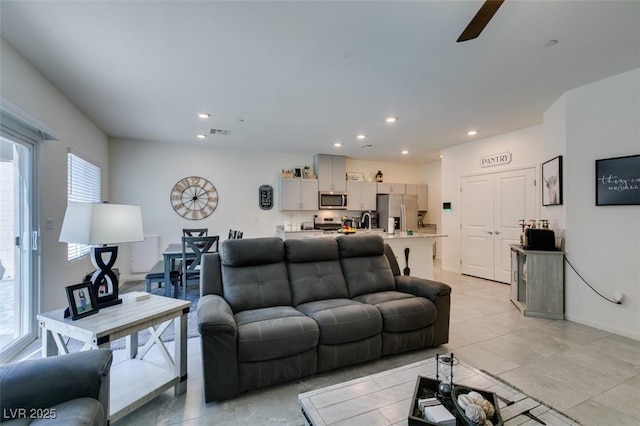 living room with healthy amount of natural light, light tile patterned floors, recessed lighting, and a ceiling fan