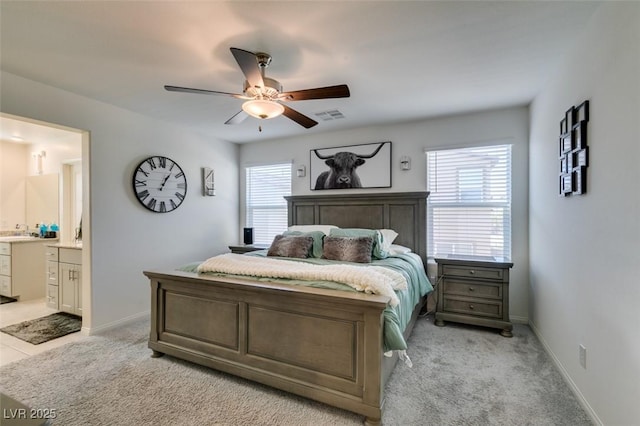 bedroom with multiple windows, connected bathroom, light colored carpet, and a sink
