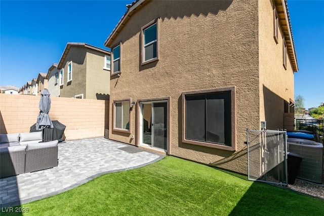 back of property with stucco siding, a patio area, central AC, and an outdoor hangout area