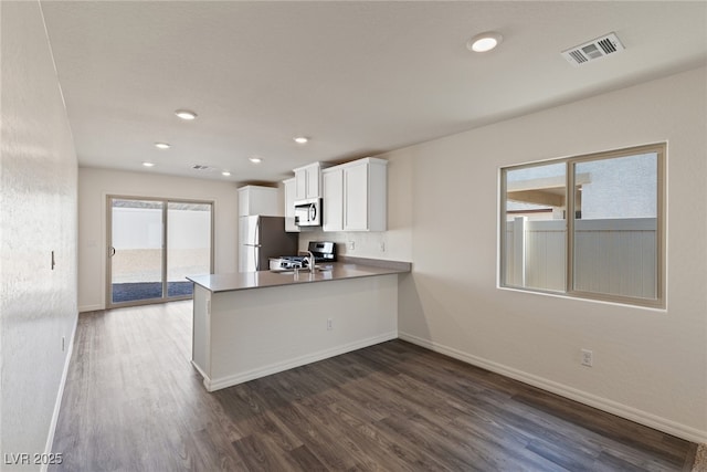 kitchen featuring appliances with stainless steel finishes, dark wood-type flooring, baseboards, and recessed lighting