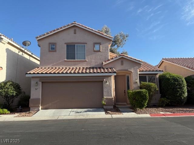 mediterranean / spanish home featuring a tile roof, stucco siding, and an attached garage
