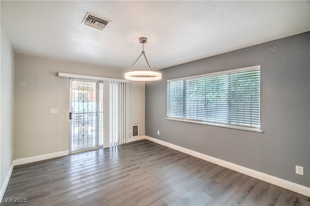 spare room featuring wood finished floors and baseboards