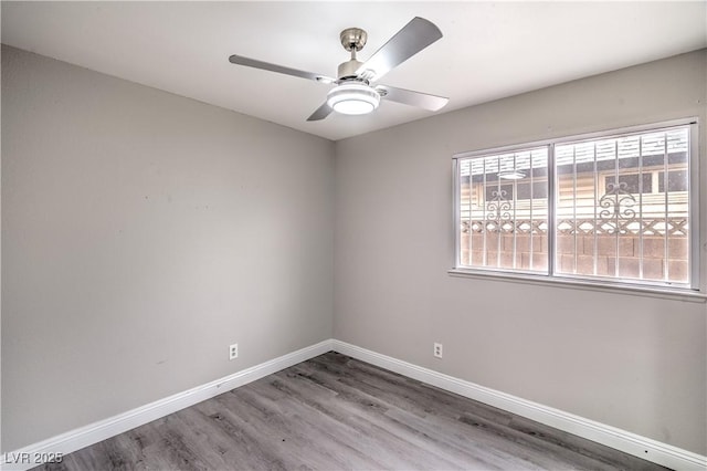 empty room with baseboards, wood finished floors, and ceiling fan