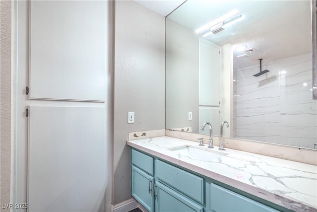 bathroom with vanity and a marble finish shower