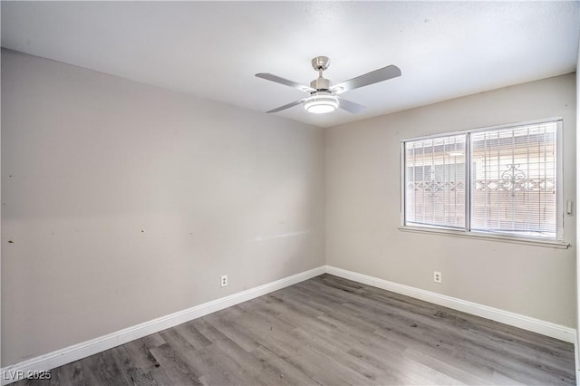 unfurnished room featuring wood finished floors, baseboards, and a ceiling fan