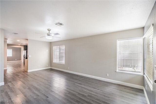 empty room with baseboards, wood finished floors, and a ceiling fan
