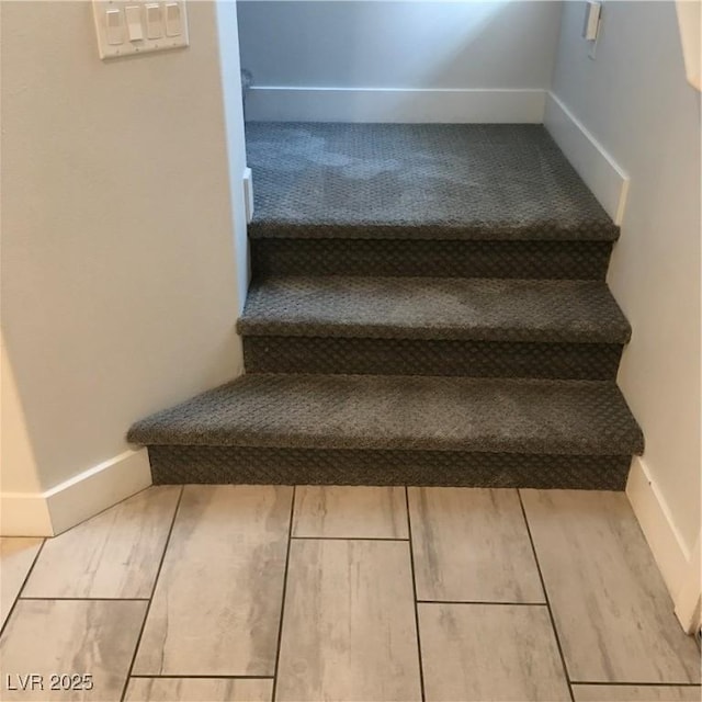 stairs featuring baseboards and wood finished floors