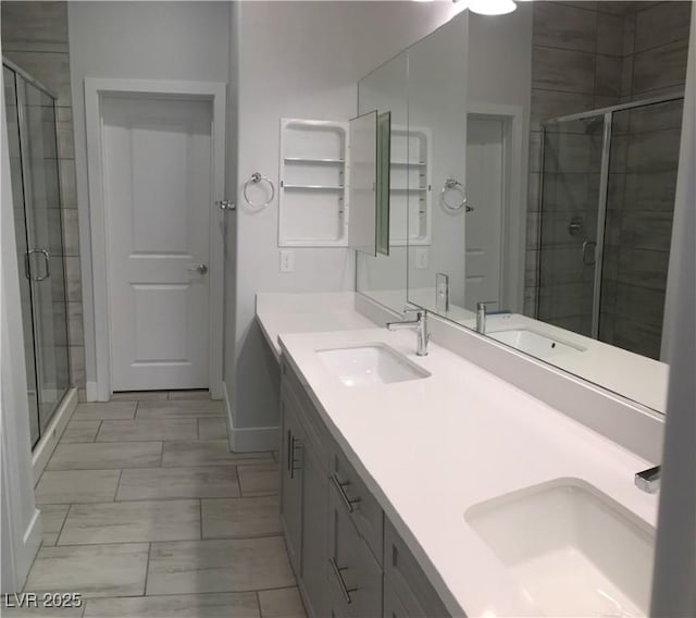 bathroom featuring marble finish floor, a shower stall, and a sink