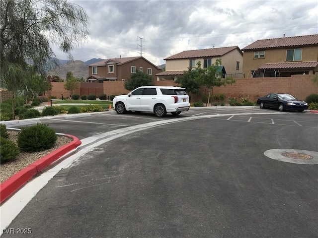 uncovered parking lot with fence and a residential view