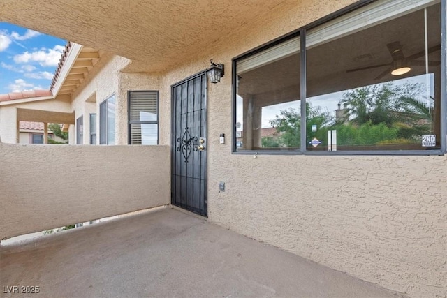 property entrance with stucco siding and a balcony