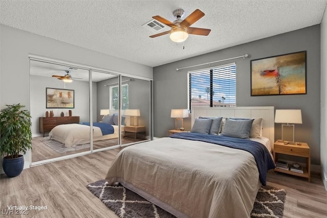1112 Observation Dr Unit 201, Las Vegas, NV 89128 - bedroom featuring wood finished floors, multiple windows, a closet, ceiling fan, and a textured ceiling