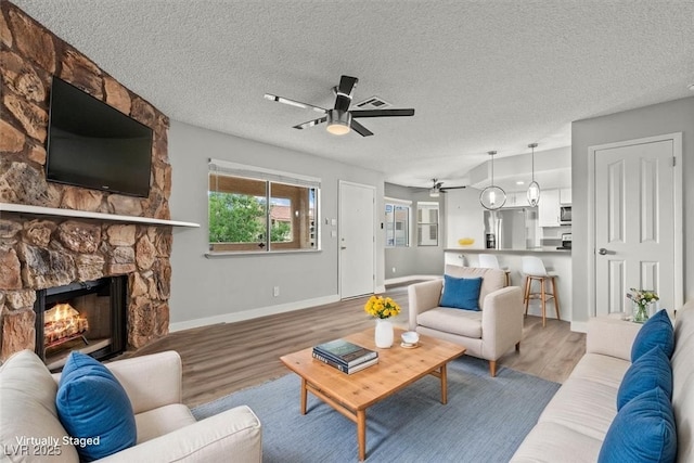 1112 Observation Dr Unit 201, Las Vegas, NV 89128 - living room with wood finished floors, a ceiling fan, a fireplace, and a textured ceiling
