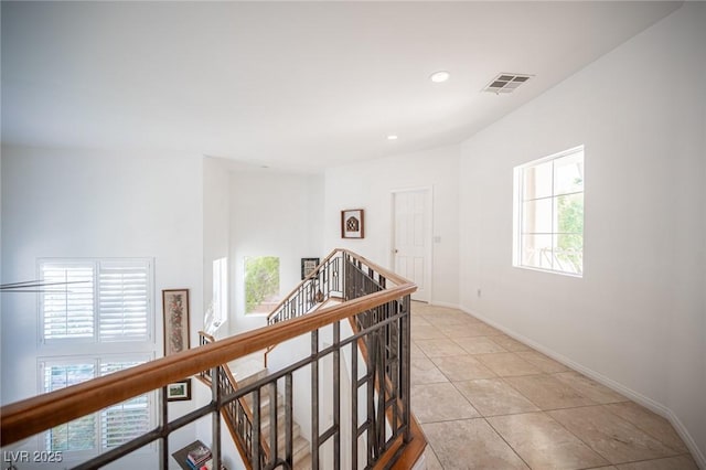 hallway with an upstairs landing, light tile patterned flooring, baseboards, and recessed lighting