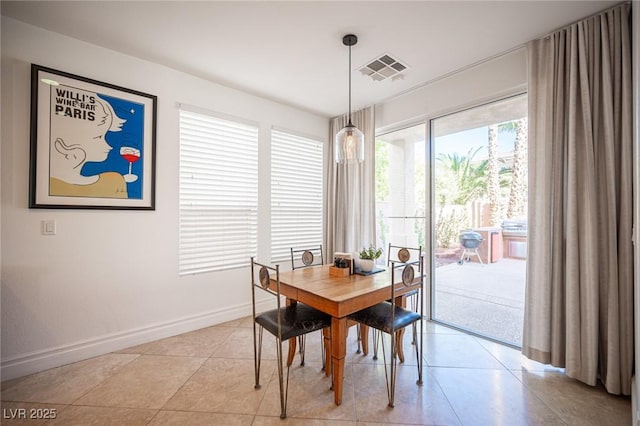dining space featuring baseboards and light tile patterned flooring
