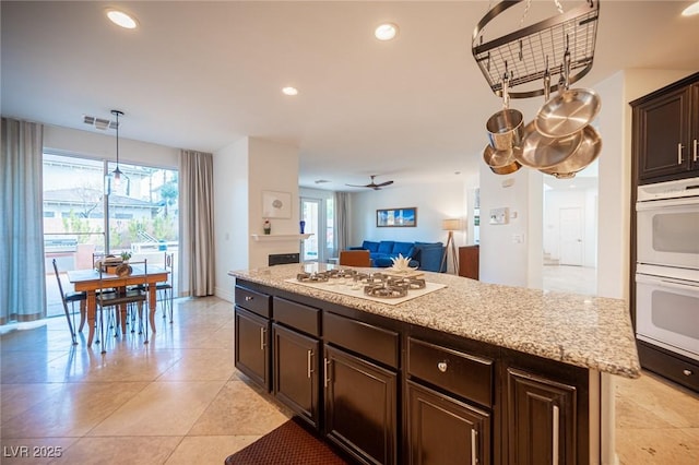 kitchen featuring white appliances, dark brown cabinetry, recessed lighting, open floor plan, and light tile patterned flooring