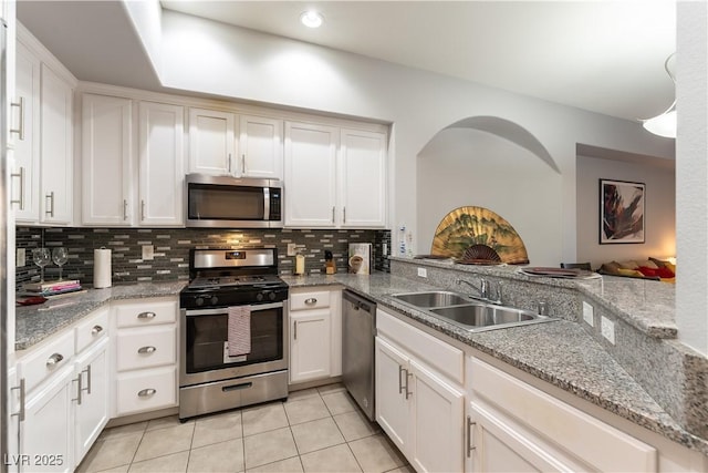 20 E Serene Ave Unit 111, Las Vegas, NV 89123 - kitchen with stainless steel appliances, a sink, light tile patterned flooring, decorative backsplash, and white cabinetry
