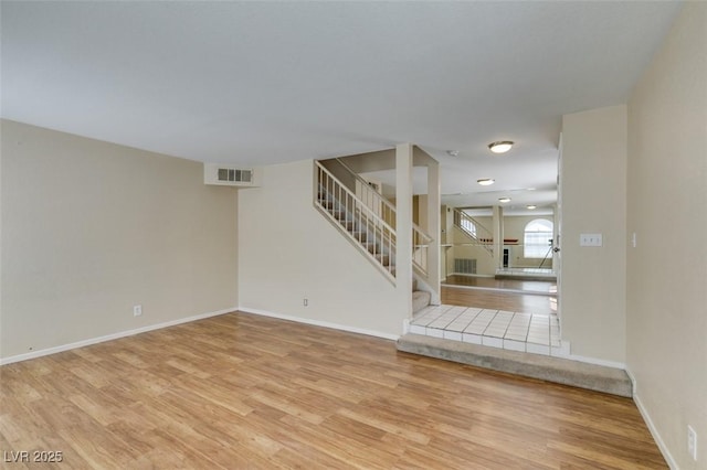 7732 Almeria Ave, Las Vegas, NV 89128 - unfurnished living room featuring stairway, light wood-type flooring, and baseboards
