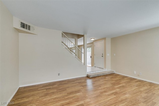 7732 Almeria Ave, Las Vegas, NV 89128 - empty room with light wood-type flooring, stairway, and baseboards