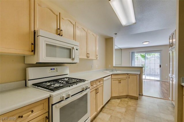 7732 Almeria Ave, Las Vegas, NV 89128 - kitchen with white appliances, light brown cabinets, a peninsula, light countertops, and a sink