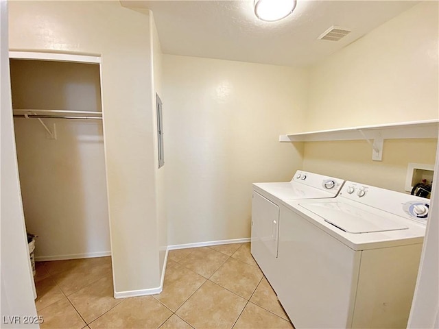 laundry room with washer and clothes dryer, light tile patterned flooring, and baseboards