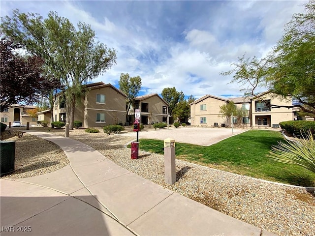 view of front of property featuring a front yard, a residential view, and stucco siding