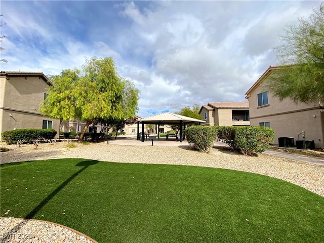 view of green lawn featuring a gazebo and cooling unit