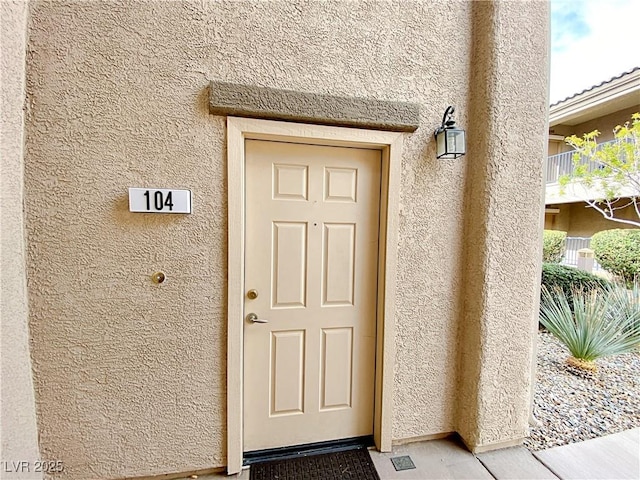 entrance to property featuring stucco siding