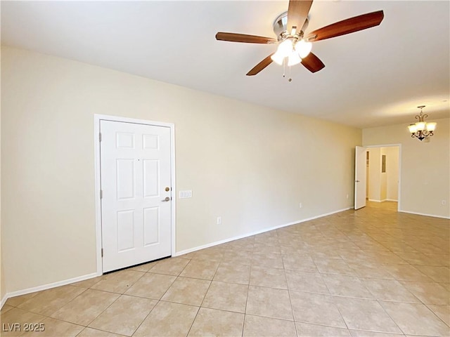 empty room featuring a ceiling fan, a chandelier, light tile patterned flooring, and baseboards