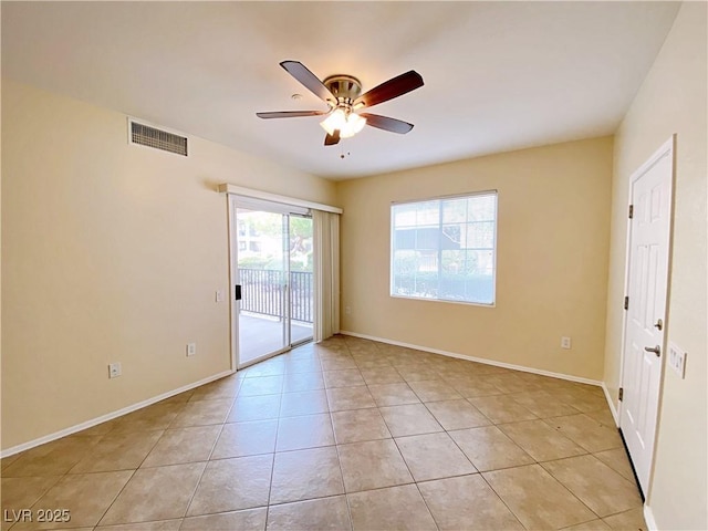 unfurnished room featuring ceiling fan, light tile patterned floors, and baseboards
