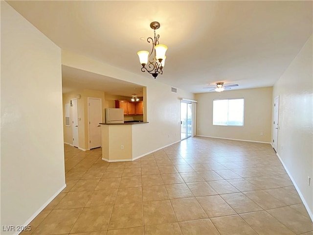 empty room featuring ceiling fan, light tile patterned floors, a chandelier, and baseboards