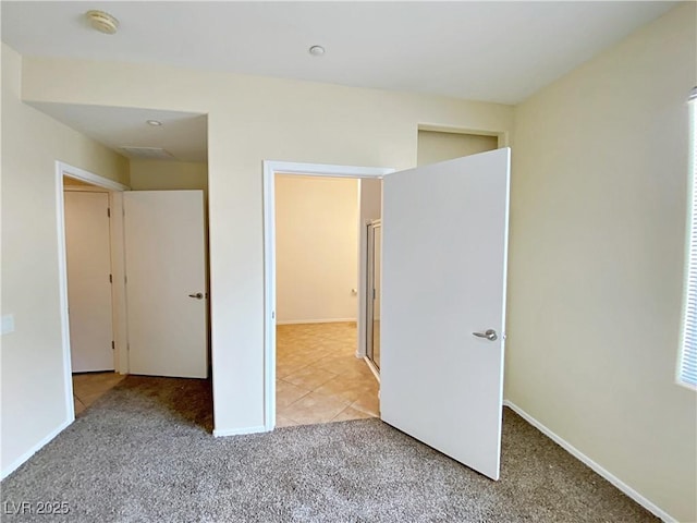 unfurnished bedroom featuring light carpet and baseboards