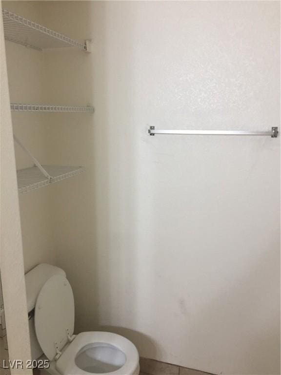bathroom featuring toilet and tile patterned flooring