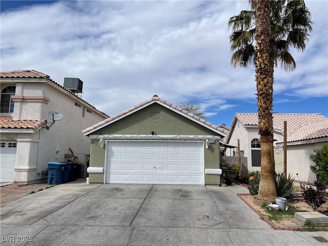 mediterranean / spanish-style home featuring driveway, stucco siding, an attached garage, a tile roof, and central AC