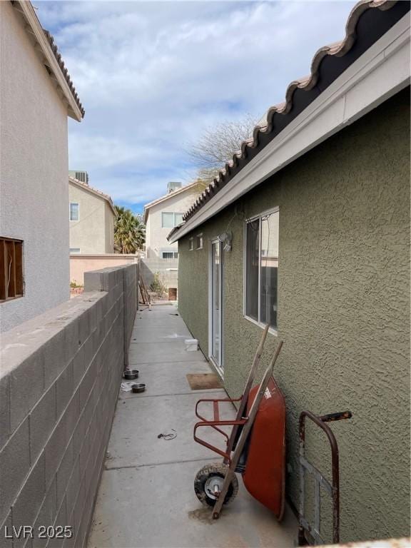view of property exterior with stucco siding and a tile roof