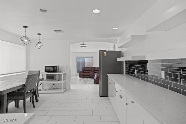 kitchen featuring stainless steel appliances, tasteful backsplash, white cabinetry, light countertops, and open shelves