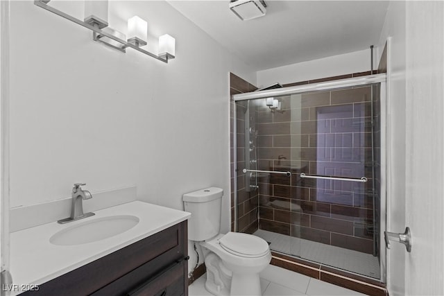 bathroom featuring a shower stall, toilet, vanity, and tile patterned flooring