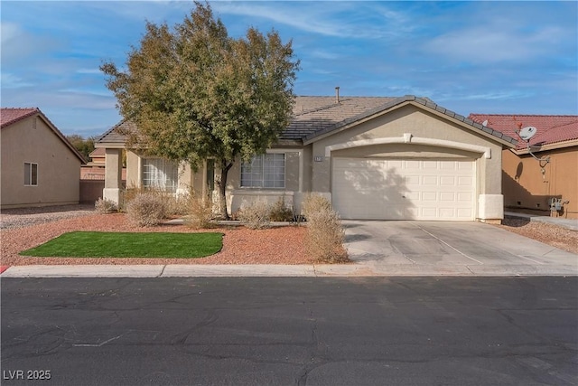 view of front of house featuring concrete driveway, a garage, stucco siding, and a tile roof