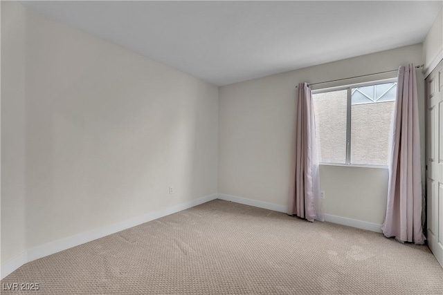 spare room with light colored carpet and baseboards