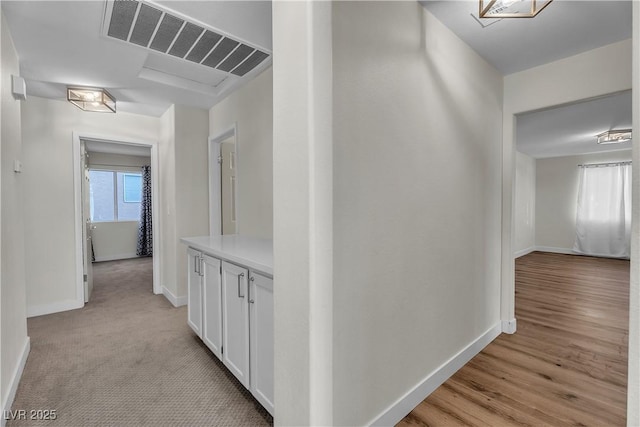 corridor featuring baseboards and light wood-style floors