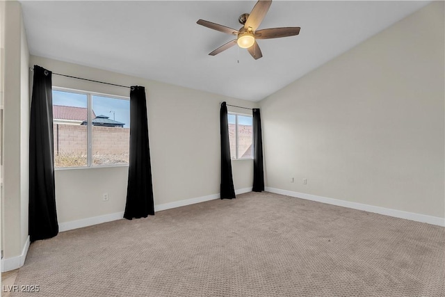 spare room featuring plenty of natural light, ceiling fan, vaulted ceiling, and carpet