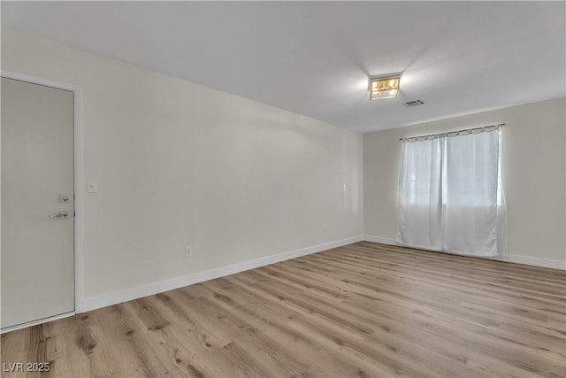 empty room featuring light wood-style floors and baseboards