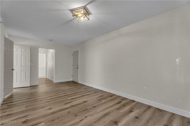 unfurnished room with baseboards and light wood-type flooring