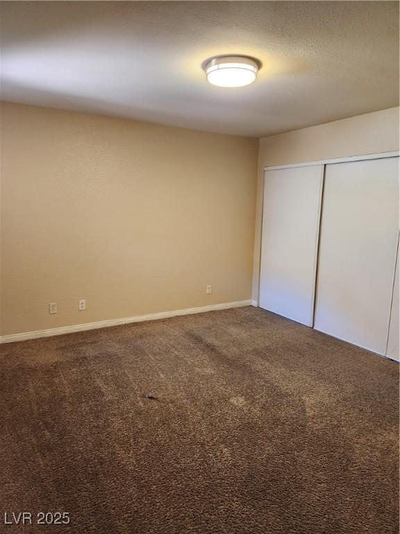 2974 Juniper Hills Blvd Unit 104, Las Vegas, NV 89142 - unfurnished bedroom with carpet flooring, baseboards, and a closet