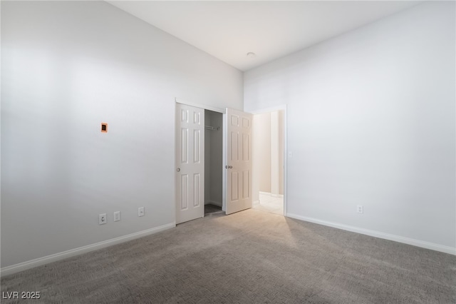 unfurnished bedroom with carpet floors, baseboards, and a closet